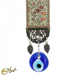 Evil Eye amulet with beige carpet background.