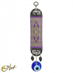 Evil Eye amulet with purple carpet background.